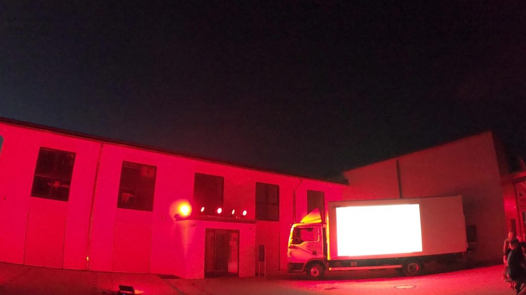 Illuminiertes Firmengebäude mit Projektion auf einem Lkw – Night of Light 2020